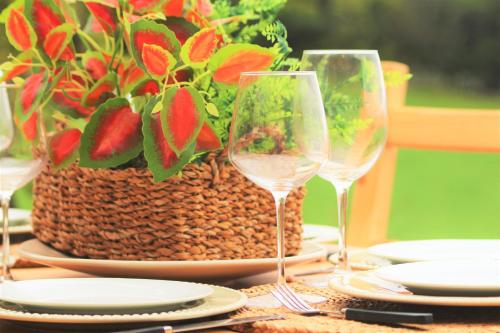 a table with two wine glasses and a basket of flowers at Pike Cliffs I in Prainha de Cima