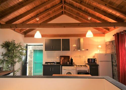 a kitchen with black cabinets and a white refrigerator at Pike Cliffs I in Prainha de Cima