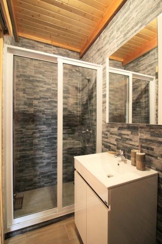 a bathroom with a sink and a glass shower at Pike Cliffs I in Prainha de Cima