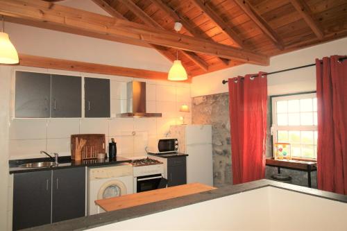 a kitchen with a stove and a refrigerator at Pike Cliffs I in Prainha de Cima
