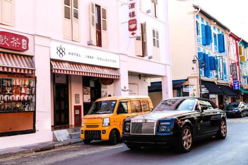 two cars are parked on a city street at Rest Chinatown Hotel in Singapore