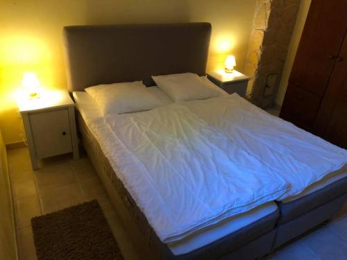 a bed with white sheets and pillows in a room at Apartamenty Beata Wisełka in Wisełka