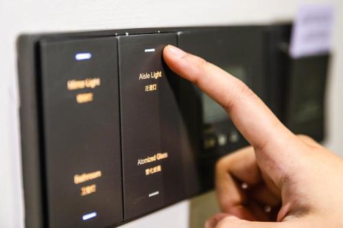 a person is touching a microwave with their finger at Rest Chinatown Hotel in Singapore