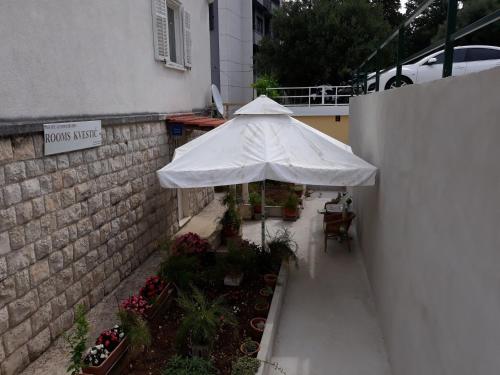 a white umbrella sitting next to a building at Rooms Kvestic in Dubrovnik