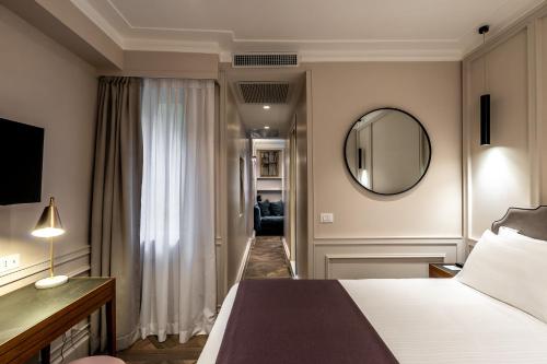 a hotel room with a bed and a mirror at Hotel Smeraldo in Rome