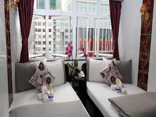 uma sala de estar com dois sofás brancos e uma janela em David Lounge em Hong Kong