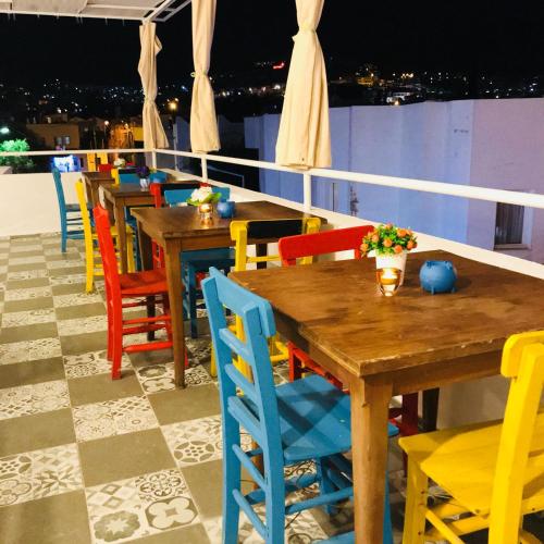 a row of tables and colorful chairs on a roof at Halikarnas Pansiyon in Bodrum City