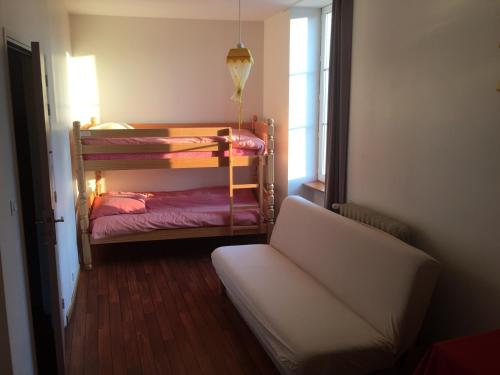 Cette petite chambre comprend des lits superposés et un canapé. dans l'établissement Au Père Tranquille, à Tinchebray