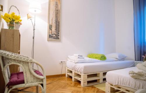a room with two twin beds and a chair at Hostel Beogradjanka in Belgrade