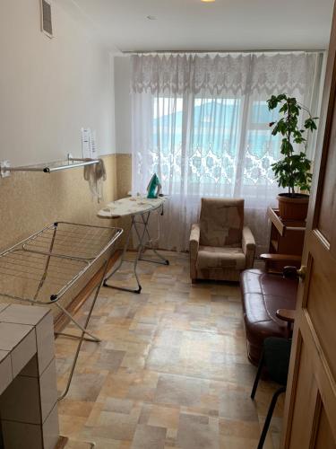 a living room with a table and a couch at Гостиница ИЛЕК in Aktobe