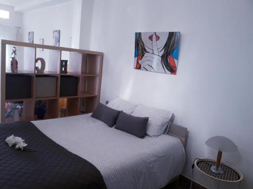 a bedroom with a bed and a painting on the wall at Sadinahome in Setúbal