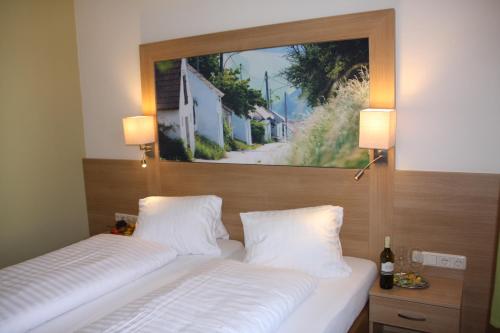 ポイスドルフにあるWeinhotel Riederのベッドルーム1室(ベッド2台付)が備わります。壁には絵画が飾られています。
