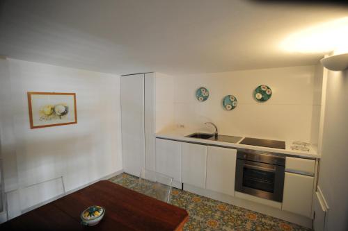 a kitchen with white walls and a sink and a stove at Maiori Dream Rental in Maiori
