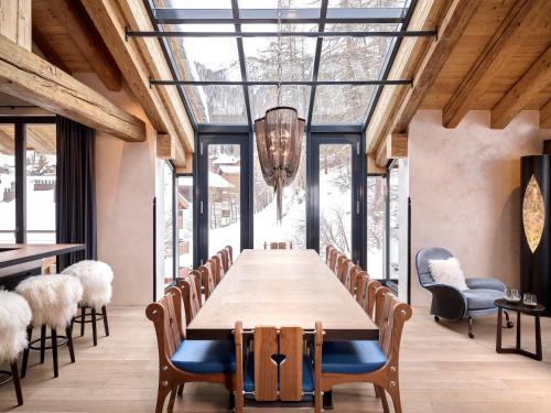 een eetkamer met een lange tafel en stoelen bij Firefly Luxury Suites in Zermatt