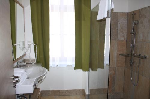W łazience znajduje się umywalka i prysznic. w obiekcie Weinhotel Rieder w mieście Poysdorf