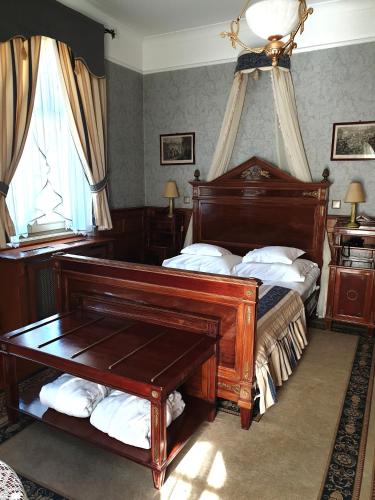 a bedroom with a wooden bed and a piano at Pałac Czarny Las (50 km od Katowic) in Woźniki