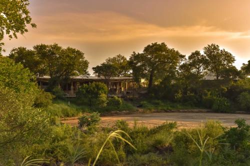 a house on the side of a road with trees at Saseka Tented Camp in Hoedspruit