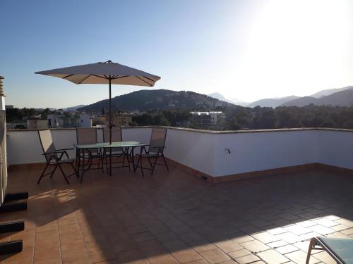 a patio with a table and an umbrella on a roof at SEA ONE. in Port de Pollensa