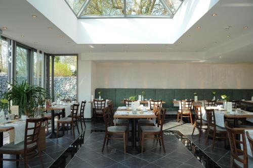 a dining room with tables and chairs and a skylight at Hotel Caroline Mathilde in Celle