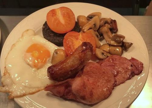 a plate of breakfast food with eggs mushrooms and meat at Old Rectory in Wem