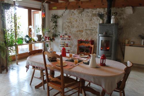 une salle à manger avec une table et une cheminée dans l'établissement Chez Louve Bleue, à Hotonnes