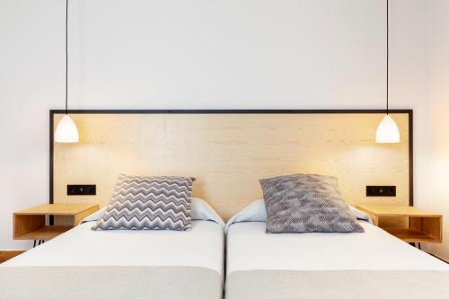 a bedroom with a large bed with two pillows at Hostal Fernando in Barcelona