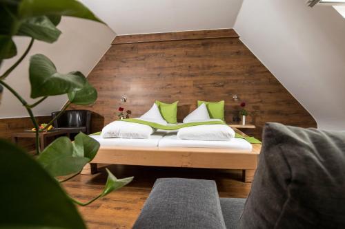 a bedroom with a bed with green pillows at Riegersburgerhof in Riegersburg