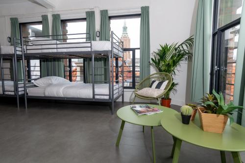 a room with bunk beds and a table and chairs at Pink Flamingo Boutique Hostel in The Hague