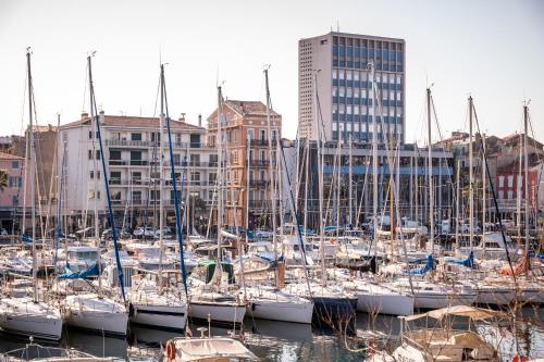 a group of boats docked in a harbor with buildings at Hôtel Mercure Toulon La Seyne-Sur-Mer in La Seyne-sur-Mer