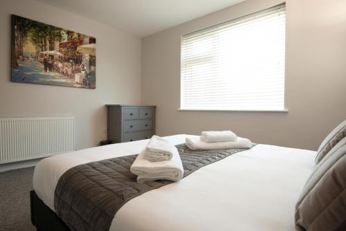 - une chambre avec un lit et 2 serviettes dans l'établissement Morley Cottage - Modern 3 bedroom, 2 bathroom house with garden in Southsea, Portsmouth, à Portsmouth