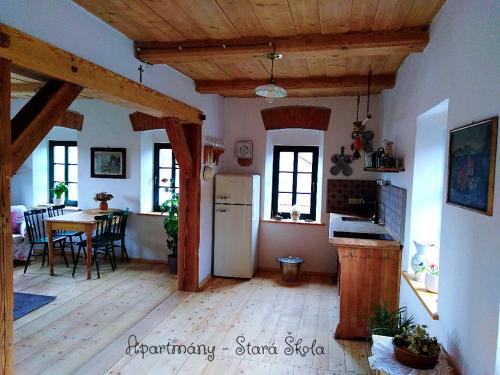 a kitchen and dining room with a refrigerator and a table at Apartmány Stará Škola in Krásná Lípa