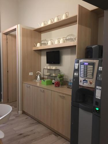 eine Küche mit einem Kühlschrank und einer Theke mit einem TV in der Unterkunft Hotel Centro in Florenz