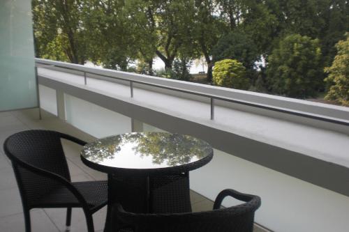 a table and chairs on a balcony with a window at INLIMA Hotel & Spa in Ponte de Lima