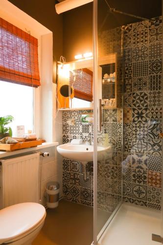 a bathroom with a shower with a sink and a toilet at Lodge Hotel Heiligendamm- digitales & rezeptionsloses Hotel in Heiligendamm