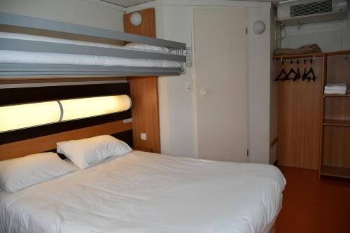 a bed in a room with two bunk beds at Premiere Classe Nevers Varennes Vauzelles in Varennes Vauzelles