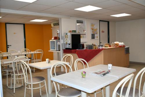 una cafetería con mesas, sillas y un mostrador en Premiere Classe Nevers Varennes Vauzelles, en Varennes Vauzelles