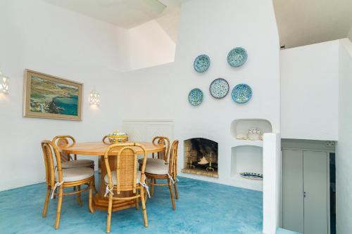 a dining room with a table and chairs and a fireplace at Liiiving in Algarve - Alvor Blue Villa in Alvor