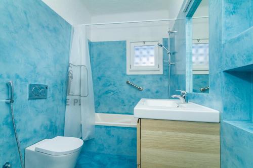 a blue bathroom with a toilet and a sink at Liiiving in Algarve - Alvor Blue Villa in Alvor