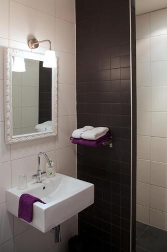 a bathroom with a white sink and a mirror at Logement-B&B Safier in Joure