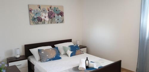 a bedroom with a bed with blue and white pillows at Apartment LANA Kaštel Stari in Kaštela