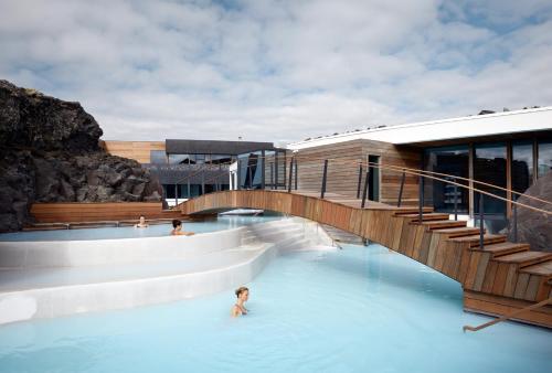 a swimming pool with stairs and people in the water at The Retreat at Blue Lagoon Iceland in Grindavík