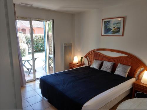 a bedroom with a bed and a sliding glass door at Les Albères Asclepieia Studio Ragnar in Argelès-sur-Mer