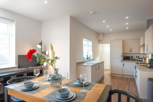 a kitchen and dining room with a table and chairs at Morley Cottage - Modern 3 bedroom, 2 bathroom house with garden in Southsea, Portsmouth in Portsmouth