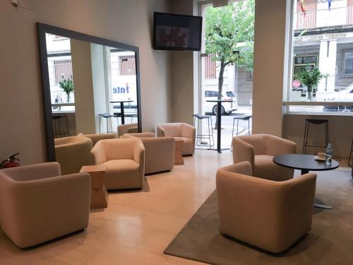 a waiting room with chairs and tables and a mirror at Carris Cardenal Quevedo in Ourense