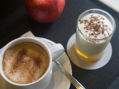 a cup of coffee and an apple on a table at Carris Cardenal Quevedo in Ourense