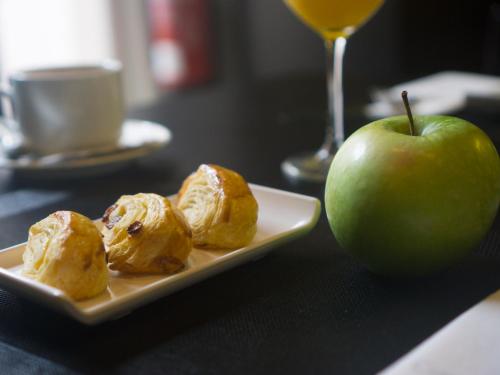 a plate of food and an apple on a table at Carris Cardenal Quevedo in Ourense
