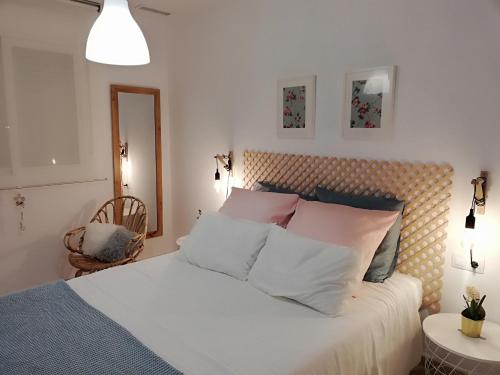 a bedroom with a bed with white and pink pillows at Paraíso en la Loma de Santa Pola in Gran Alacant