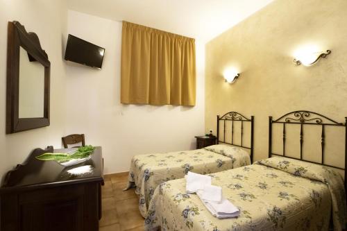 a hotel room with two beds and a mirror at Alba Marina B&B in Castelluzzo
