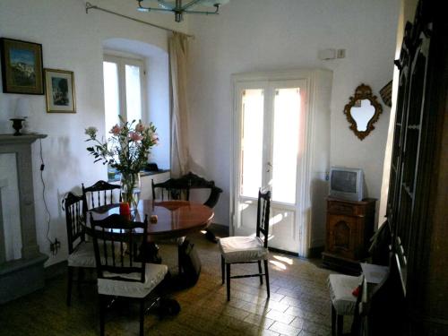 a living room with a table and chairs and a window at Belgirate il Lavatoio in Belgirate