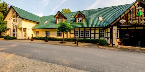 a building with a green roof on a street at Waldhotel Schipp-Hummert in Emsdetten